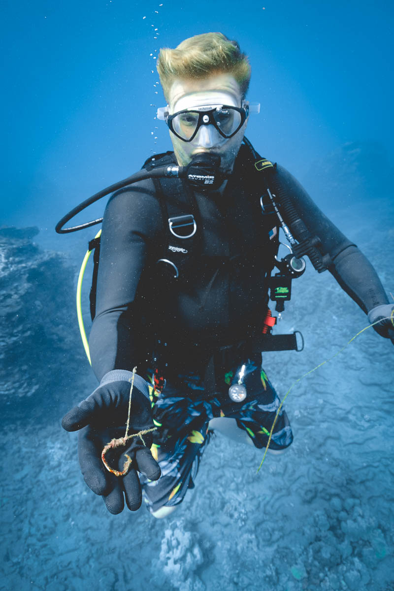 diver displaying a coral encrusted fish hook